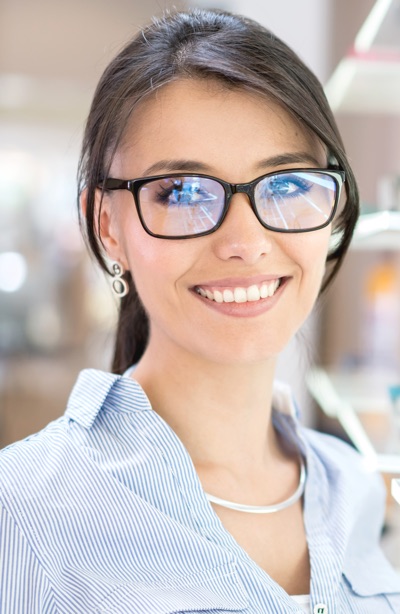 Beautiful Latin American woman buying glasses at the optician's shop - vision concepts